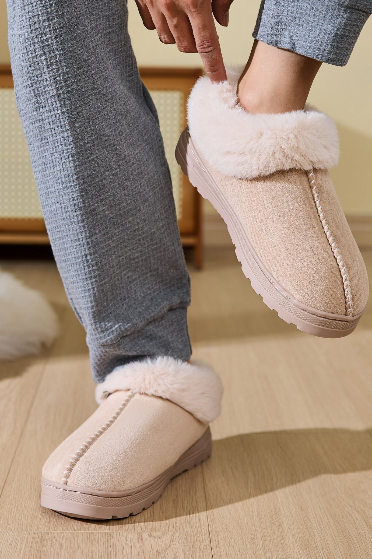 Person lounging in Faux Fur Round Toe Platform Slippers, enjoying a cozy moment at home.