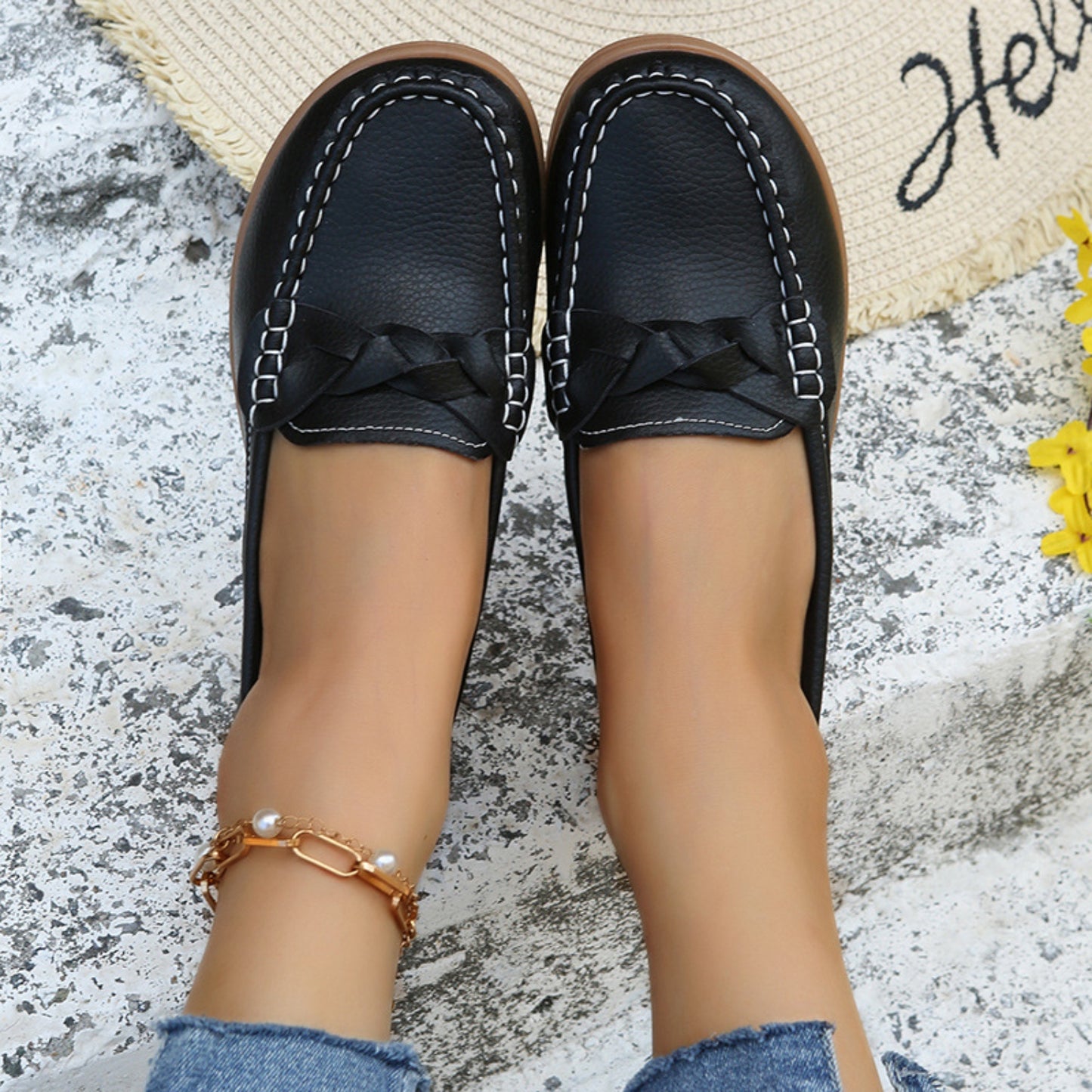 A pair of Weave Wedge Heeled Loafers placed on the floor, highlighting their design and comfort.